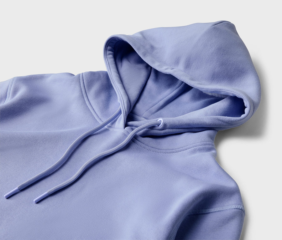 Zbliżenie na jasno fioletową bluzę z kapturem i sznurkiem na jasnym tle.