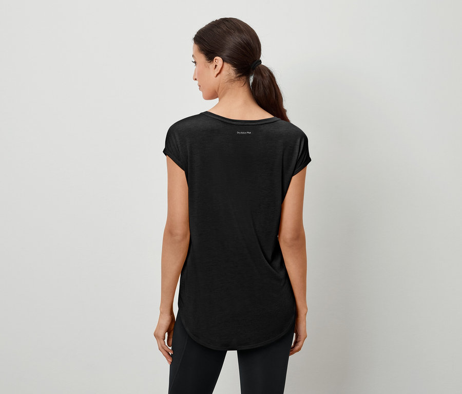 Widok z tyłu na kobietę z kucykiem, ubraną w czarną koszulkę i legginsy.