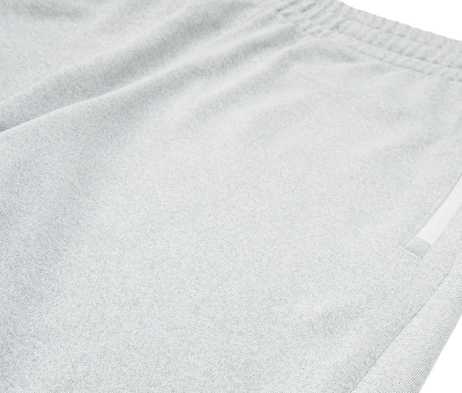 Zbliżenie szarych szortów Fila z rozcięciem na dole.