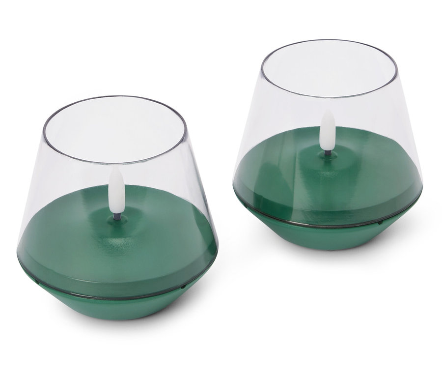 Dwa zielone, elektryczne świeczki tealight na białym tle.