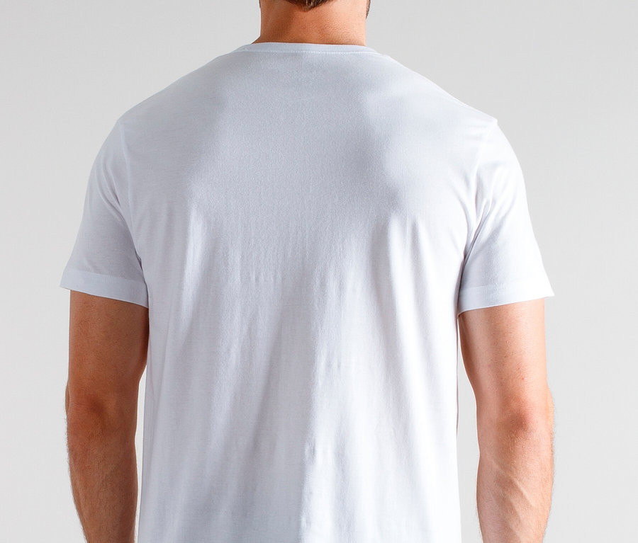 Widok z tyłu mężczyzny w białej koszulce i piżamie w kratę na neutralnym tle.