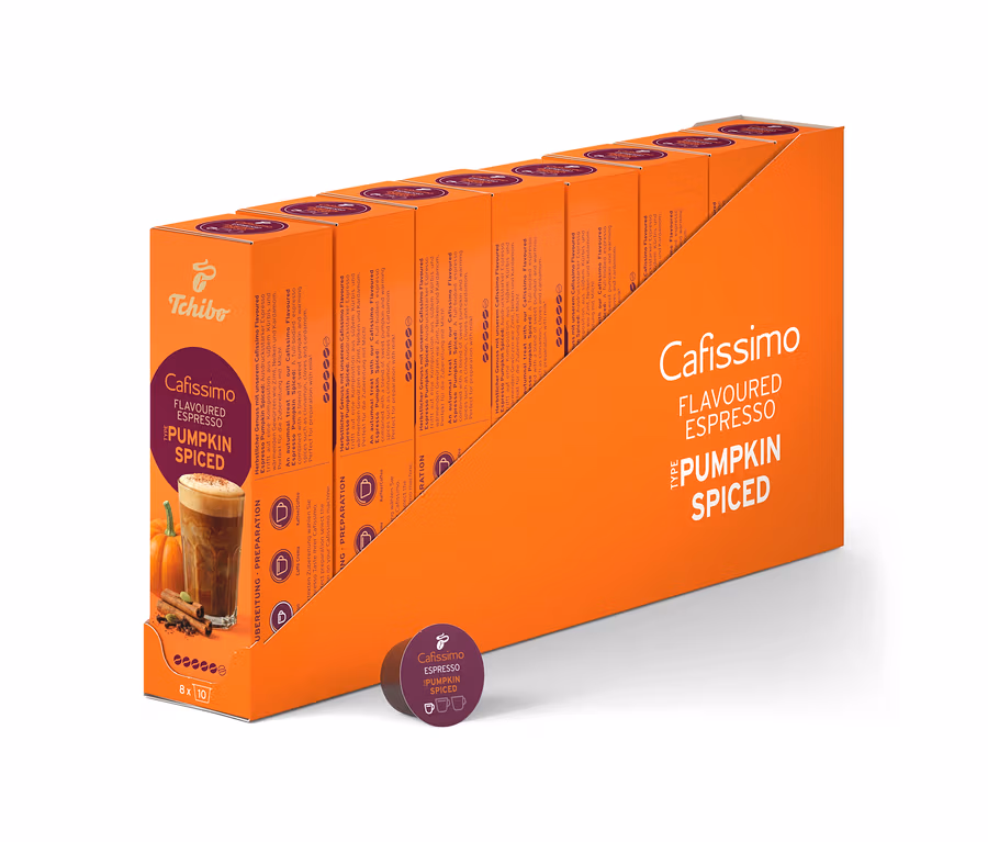 Pomarańczowy ekspozytor zawiera osiem mniejszych, pomarańczowych pudełek Cafissimo Flavoured Espresso - Pumpkin Spiced, łącznie 80 kapsułek. Przed ekspozytorem leży jedna fioletowa kapsułka.