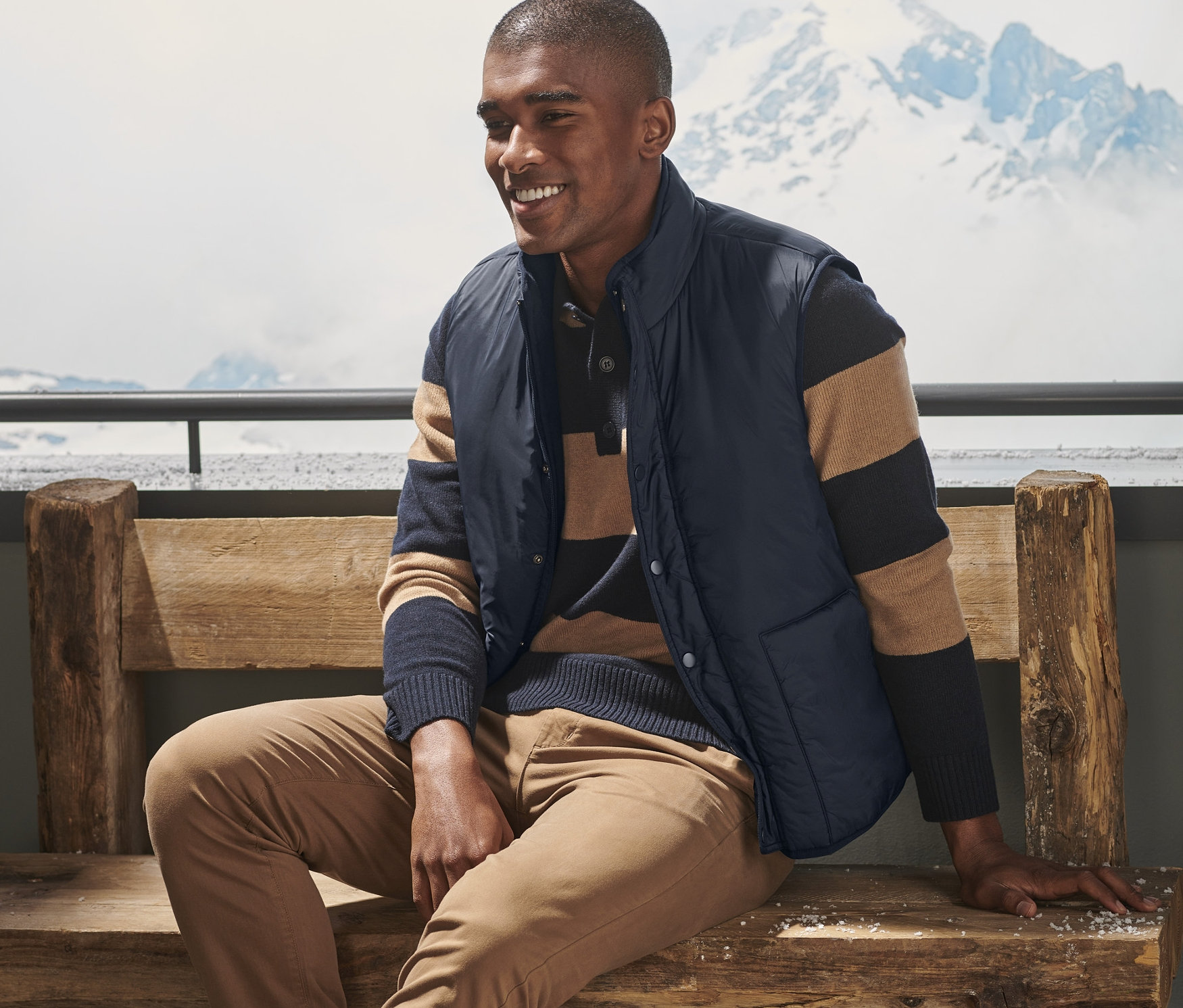 Mężczyzna siedzi na ławce i ma na sobie kamizelkę dwustronną.