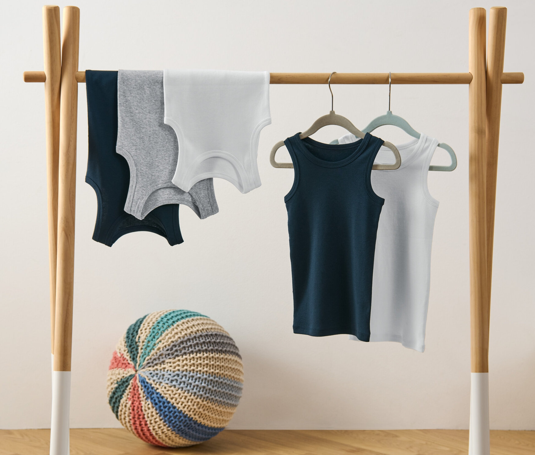 Pięć podkoszulek chłopięcych wisi na wieszaku.