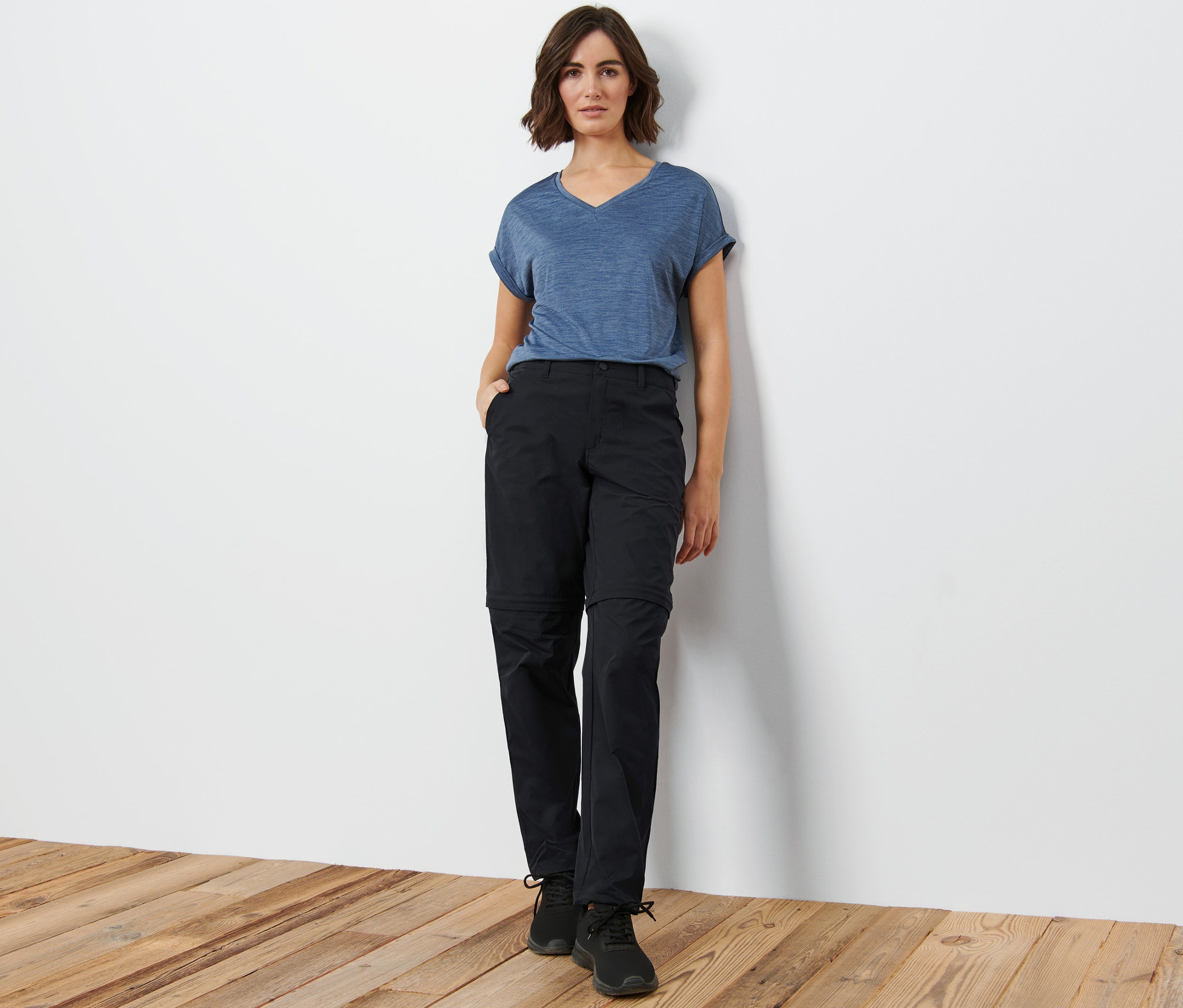 Kobieta pozuje w czarnych spodniach funkcyjnych 2 w 1.