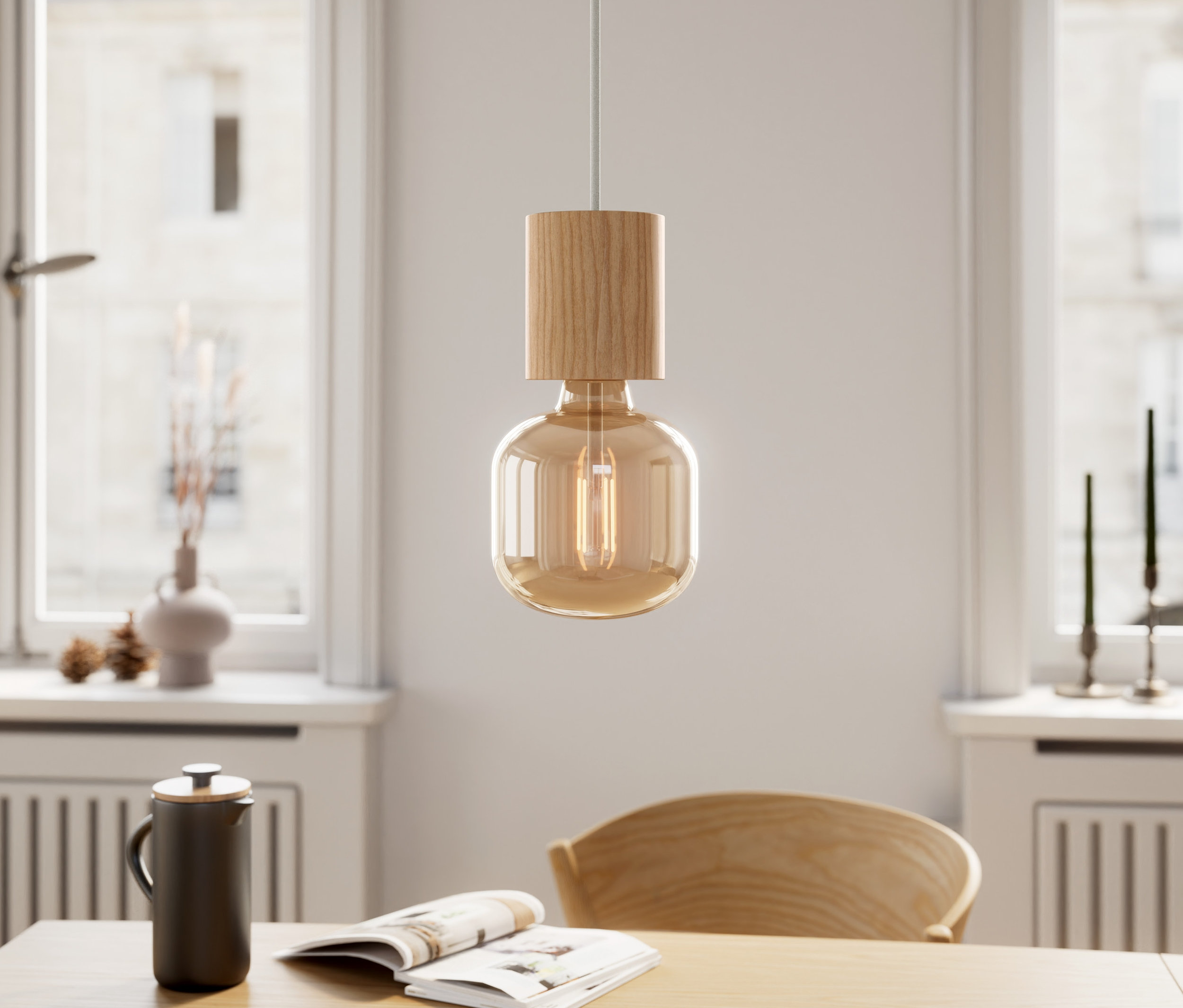 Drewniana lampa wisząca zwisa nad stołem z książką i filiżanką.
