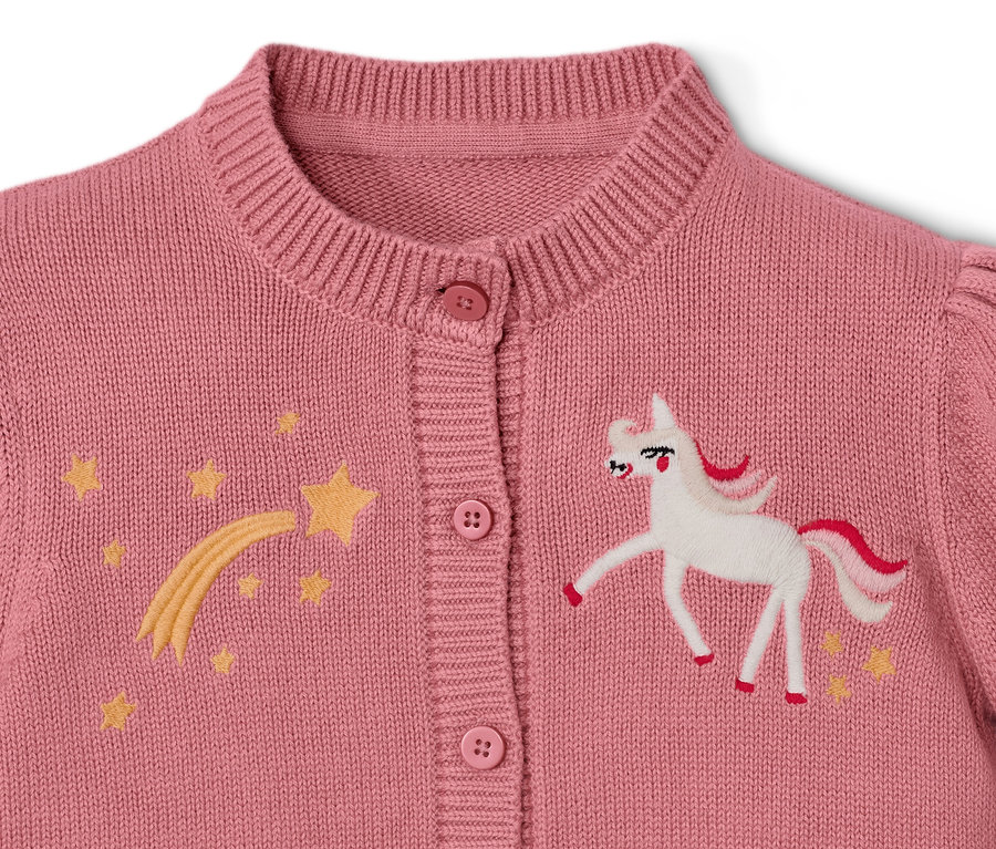 Zbliżenie na dziecięcy sweter z dzianiny z jednorożcem i gwiazdami.