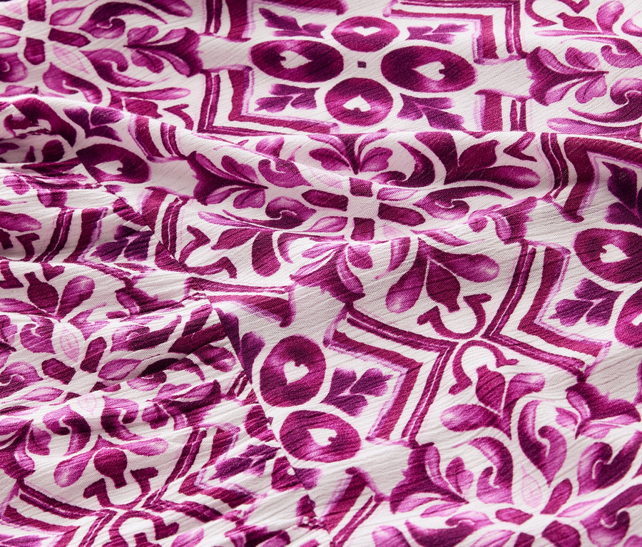 Zbliżenie na wzorzystą sukienkę z tkaniny w kolorze fioletowym.