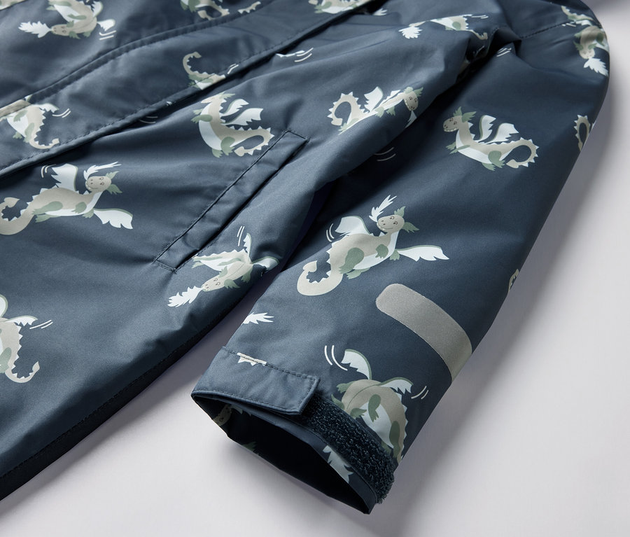 Zbliżenie na dziecięcy kombinezon przeciwdeszczowy, rycerz, z kieszenią i elementem odblaskowym.