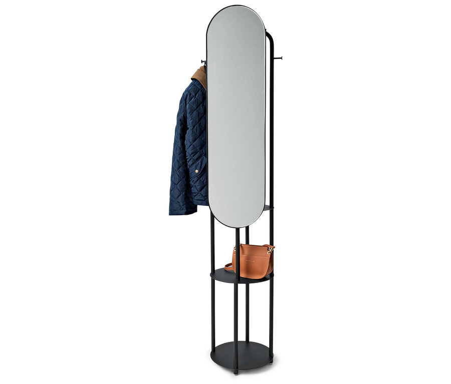 Czarny stojak z owalnym lustrem, niebieska kurtka i brązowa torebka.