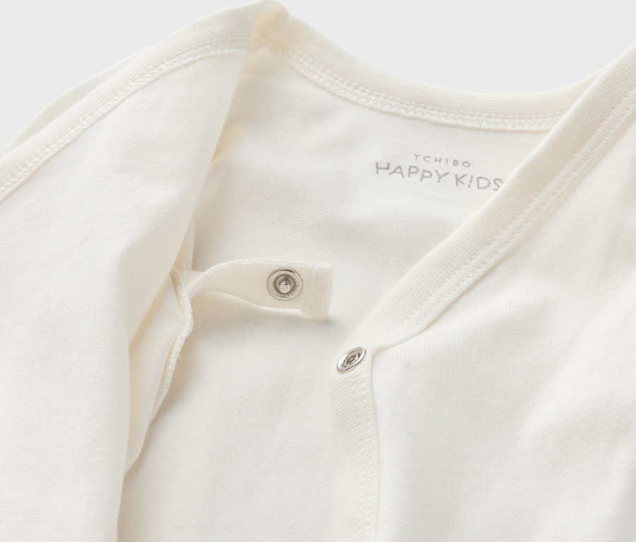 Zbliżenie na białe body niemowlęce rosnące z dzieckiem z zatrzaskami.