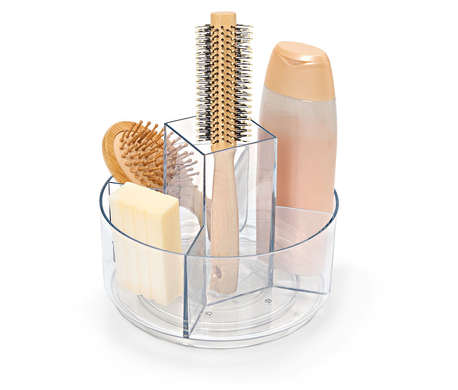 Przezroczysty, obrotowy pojemnik z mydłem, szczotką do włosów i butelką szamponu.
