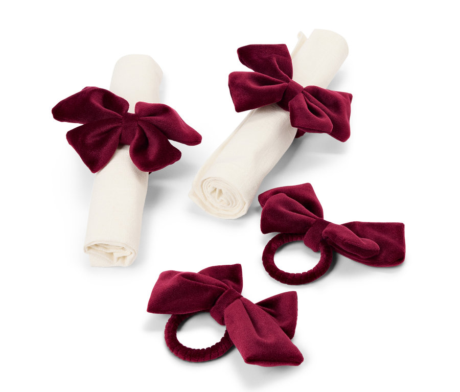 Dwie serwetki związane bordowymi aksamitnymi kokardami i dwa pojedyncze pierścienie do serwetek z bordowymi kokardami.
