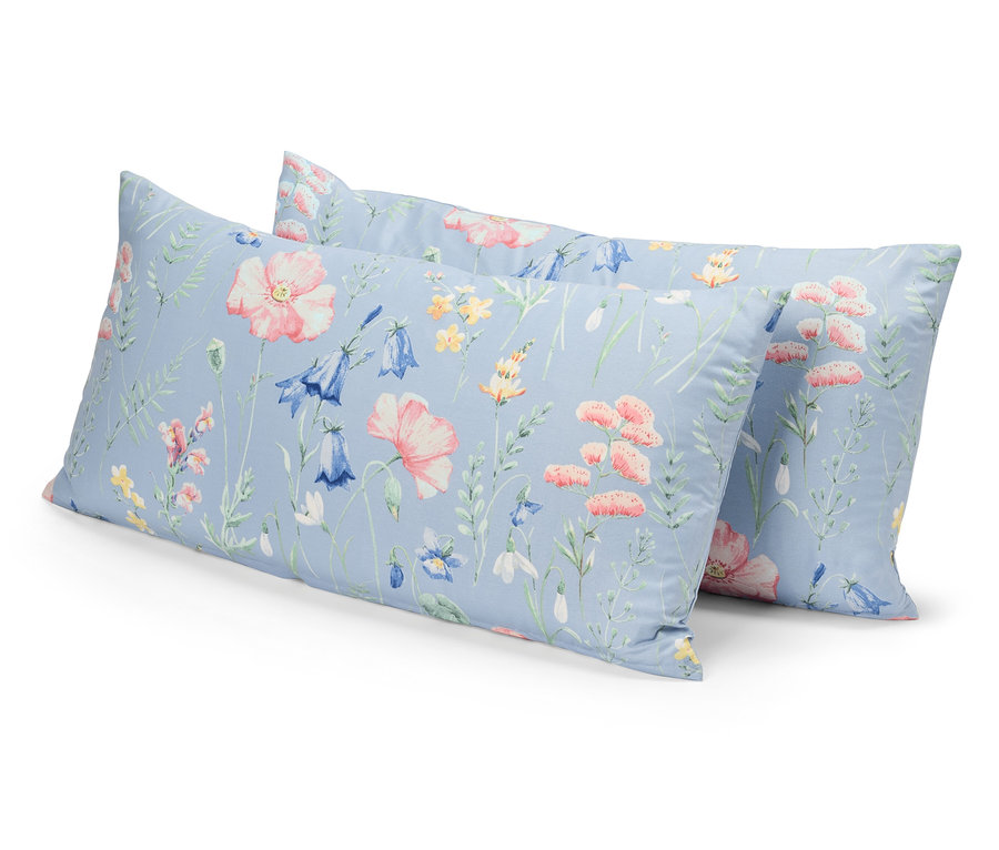 Dwie poduszki z kwiatowym wzorem na niebieskim tle leżą jedna na drugiej.