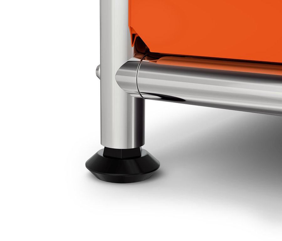 Szczegół pomarańczowej szafki z chromowaną nogą i czarną stopką.