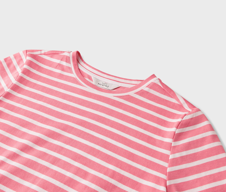 Zbliżenie różowo-białej koszulki w poziome paski.