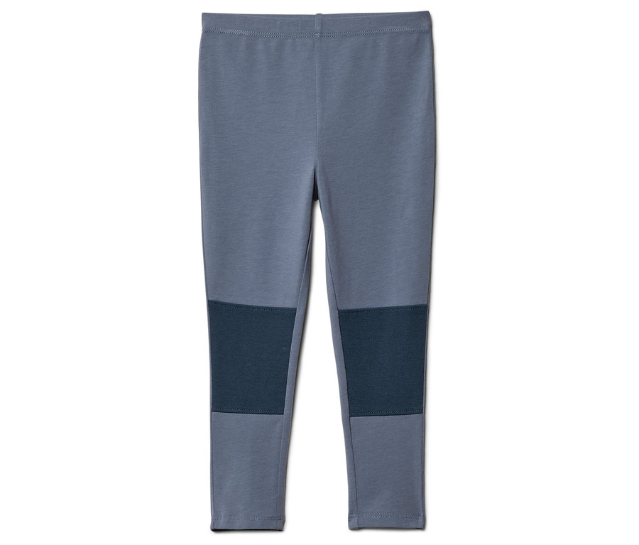 Szare legginsy z granatowymi naszywkami na kolanach leżą na białym tle.