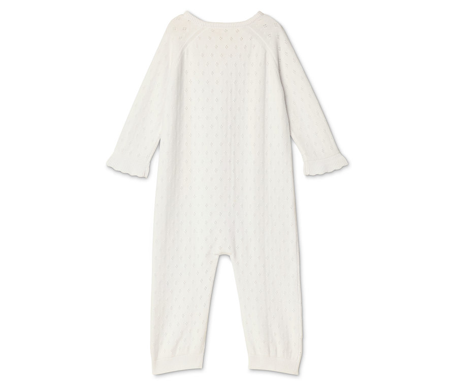 Biały kombinezon niemowlęcy z długimi rękawami i nogawkami leży na białym tle.