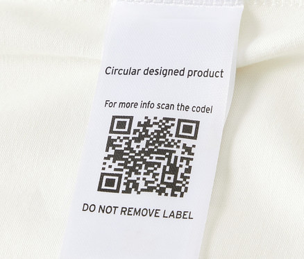 Zbliżenie na body niemowlęce rosnące z dzieckiem z kodem QR na etykiecie.