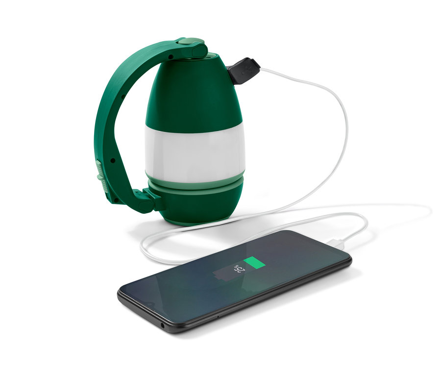 Wielofunkcyjna lampa kempingowa ładuje telefon komórkowy.