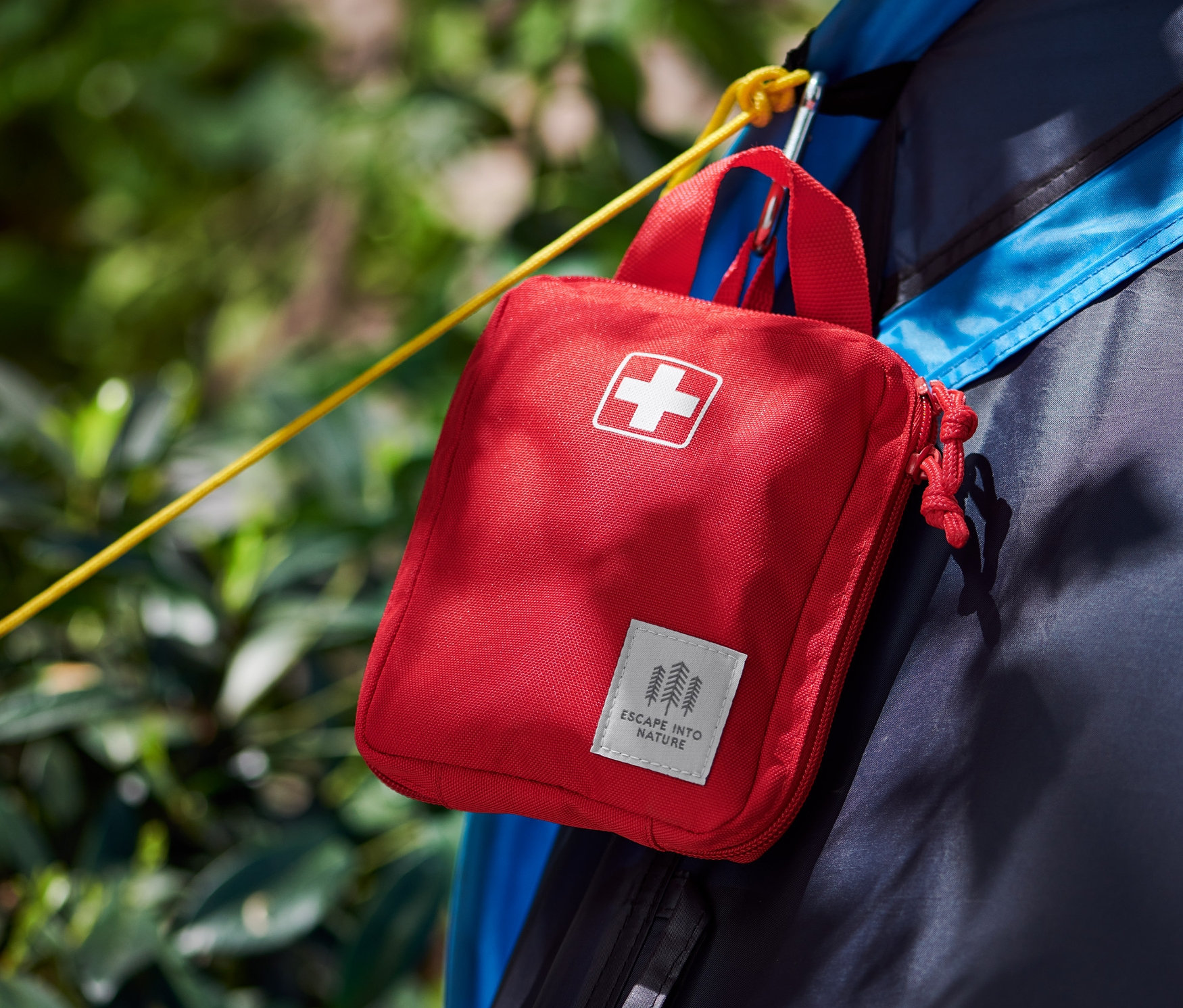 Czerwona apteczka pierwszej pomocy wisi na namiocie.
