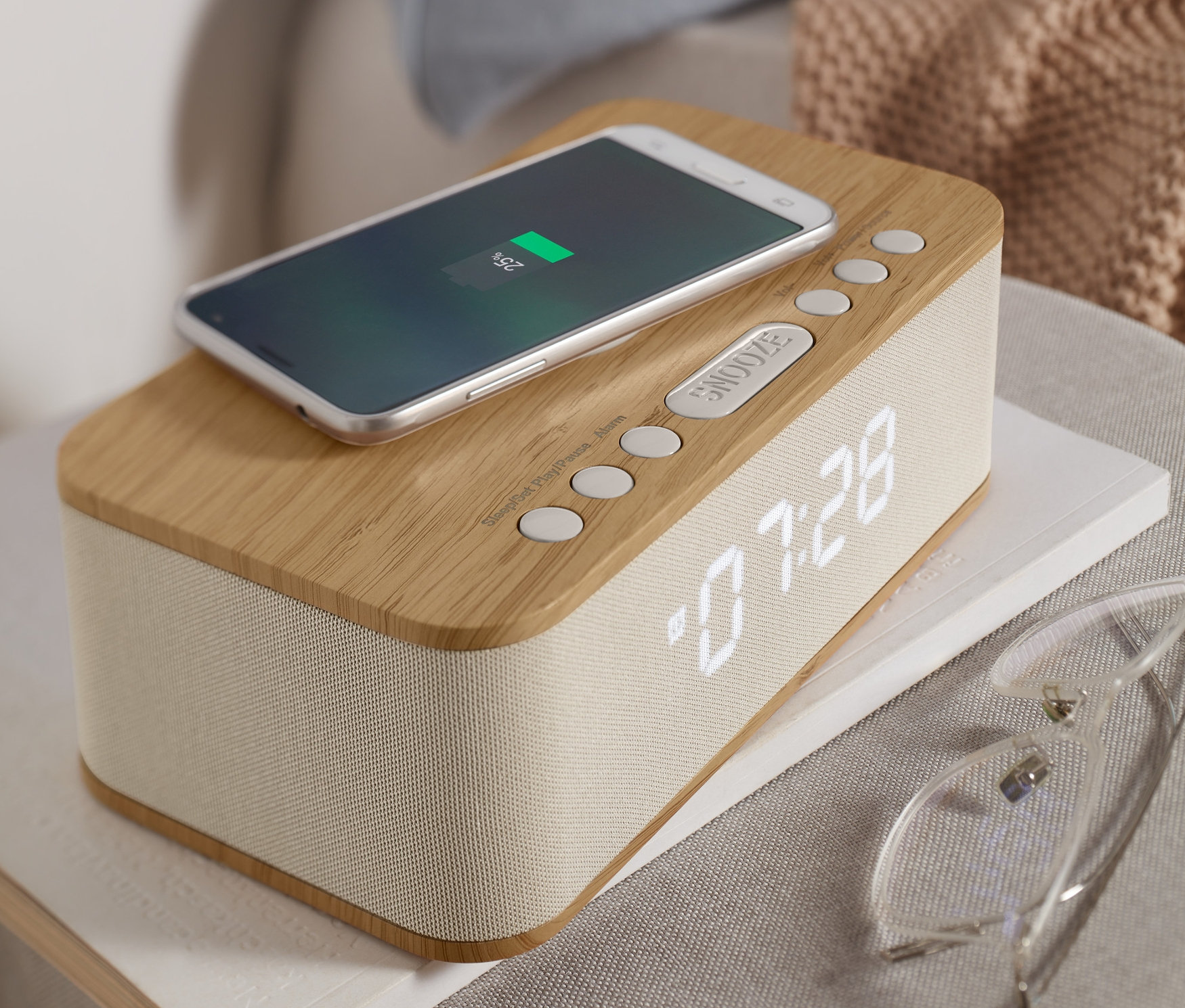 Telefon ładuje się na budziku Bluetooth® z funkcją bezprzewodowej ładowarki.