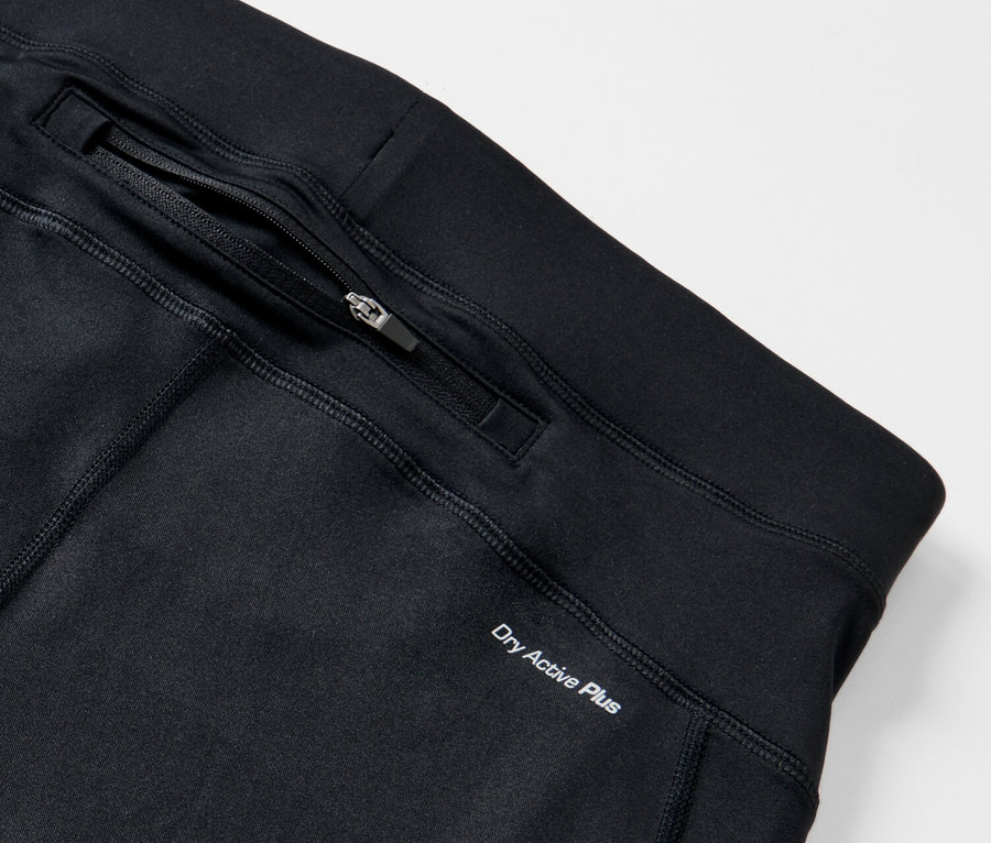 Zbliżenie na czarne legginsy do biegania z kieszenią na zamek i napisem Dry Active Plus.
