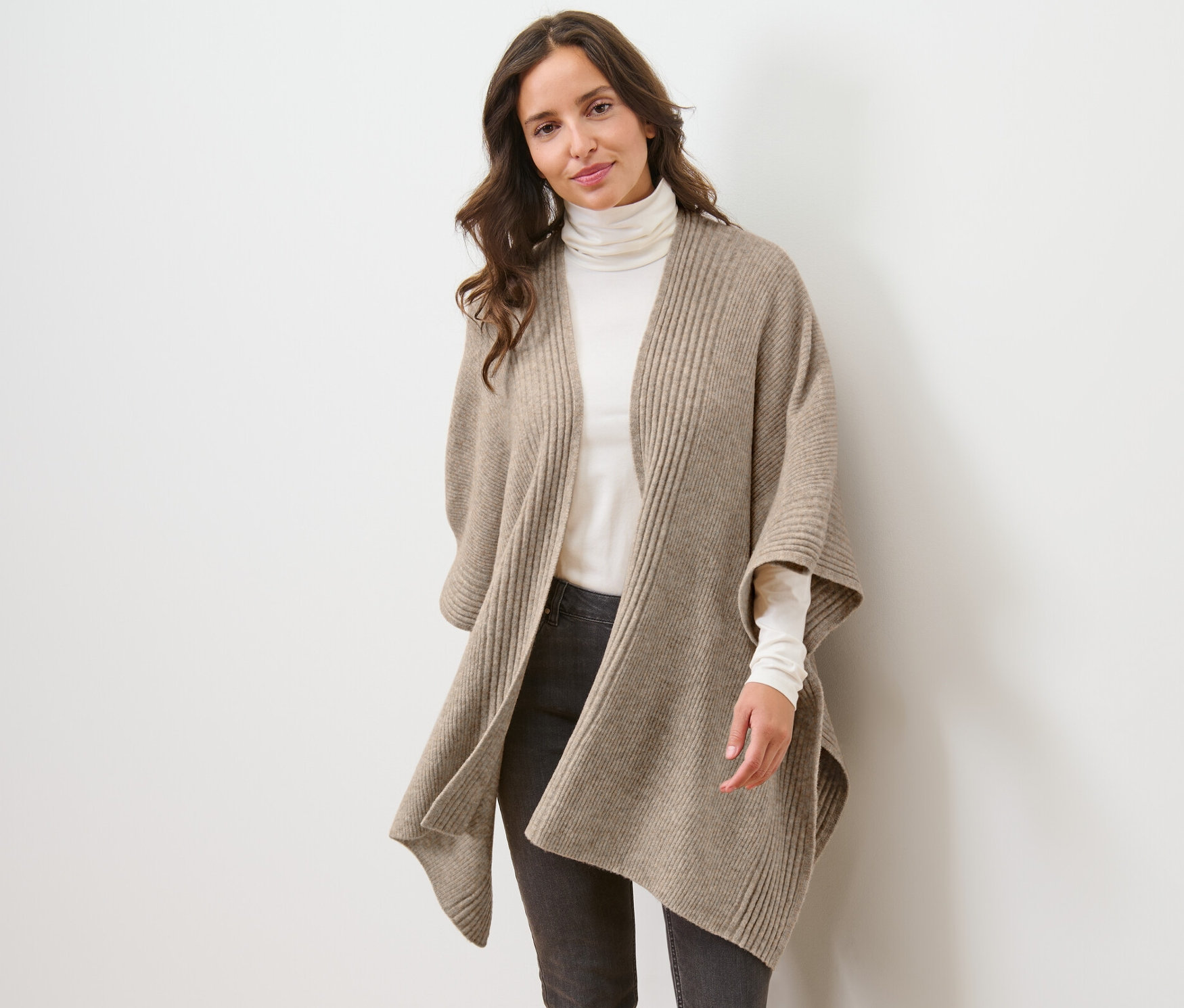 Kobieta ma na sobie ponczo z dzianiny.