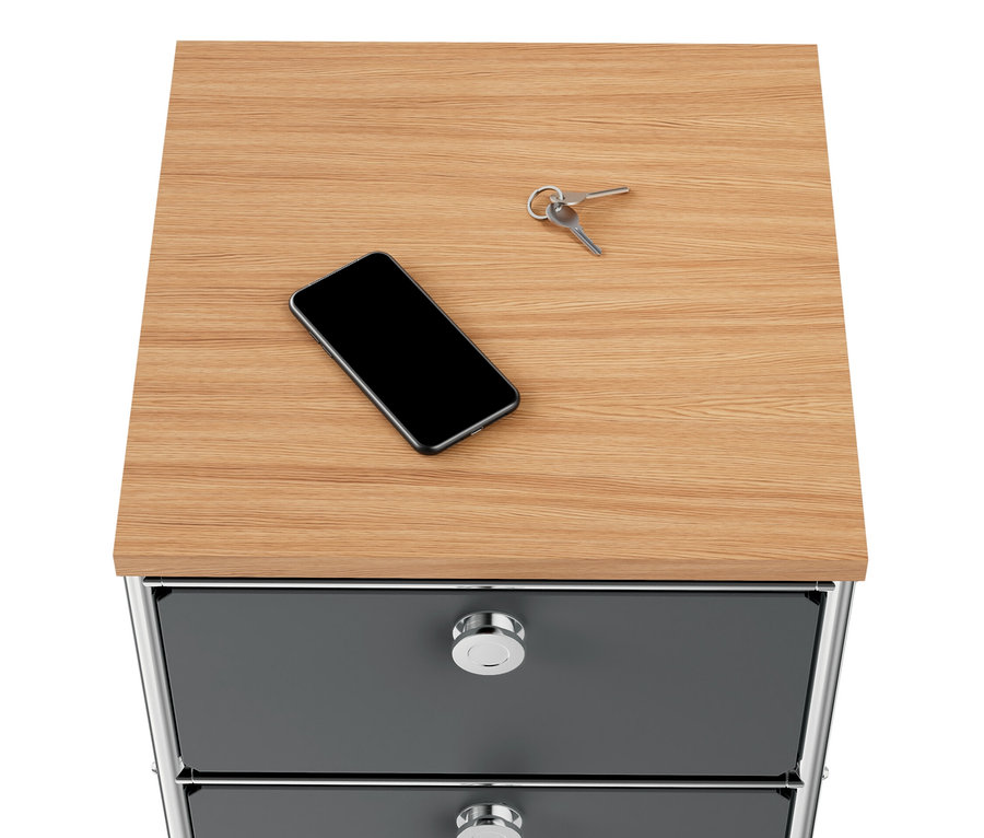 Na szarej, wąskiej komodzie metalowej „CN3” z drewnianym blatem i 2 szufladami leżą telefon i klucze.