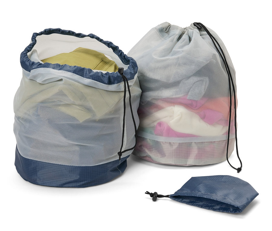 Dwa worki z siatki na zewnątrz, jeden otwarty i pełen ubrań, drugi zamknięty oraz pusta torba.