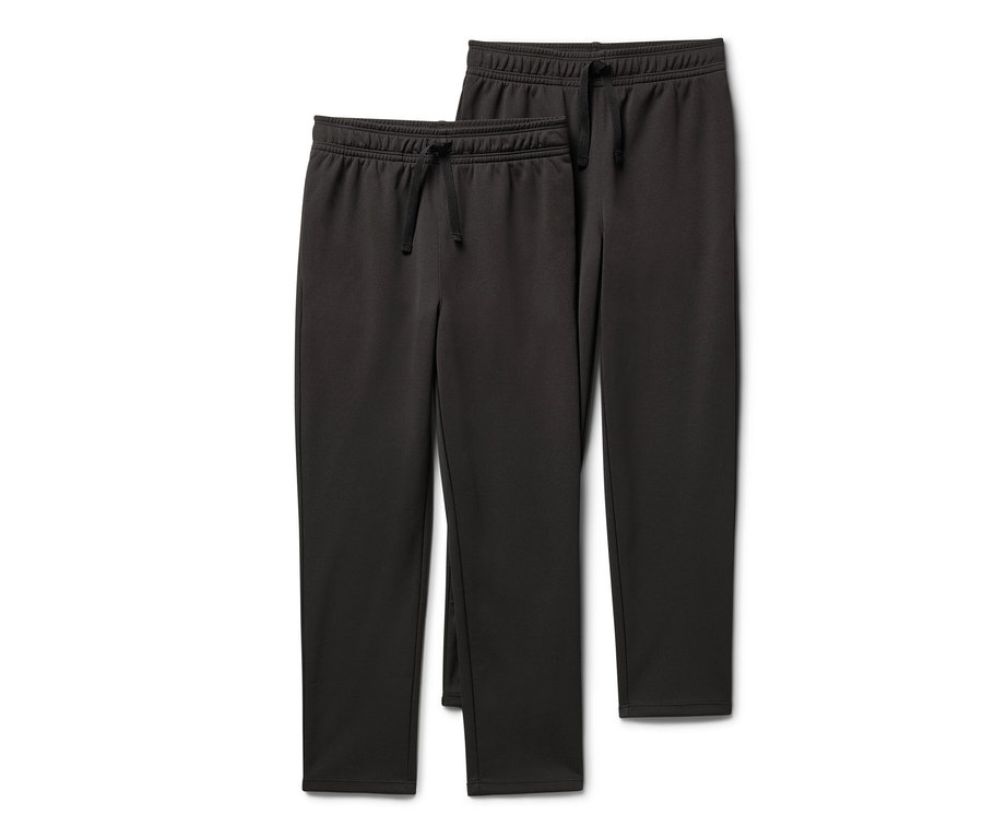 Dwie pary spodni sportowych dla dzieci leżą na sobie.