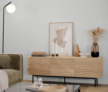 Brązowo-szara 3-osobowa sofa sztruksowa, czarna lampa stojąca ze szklaną kulą, szafka pod telewizor »Finnsbo« i dwuczęściowy zestaw stolików w salonie.