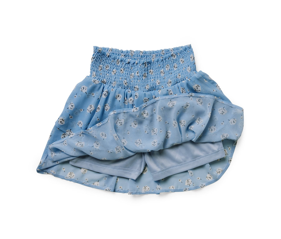 Niebieska spódnica ze spodenkami w kwiatowy wzór.