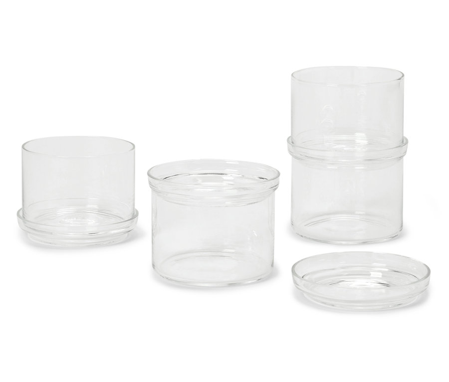 Cztery szklane słoiki o różnych rozmiarach na białym tle.