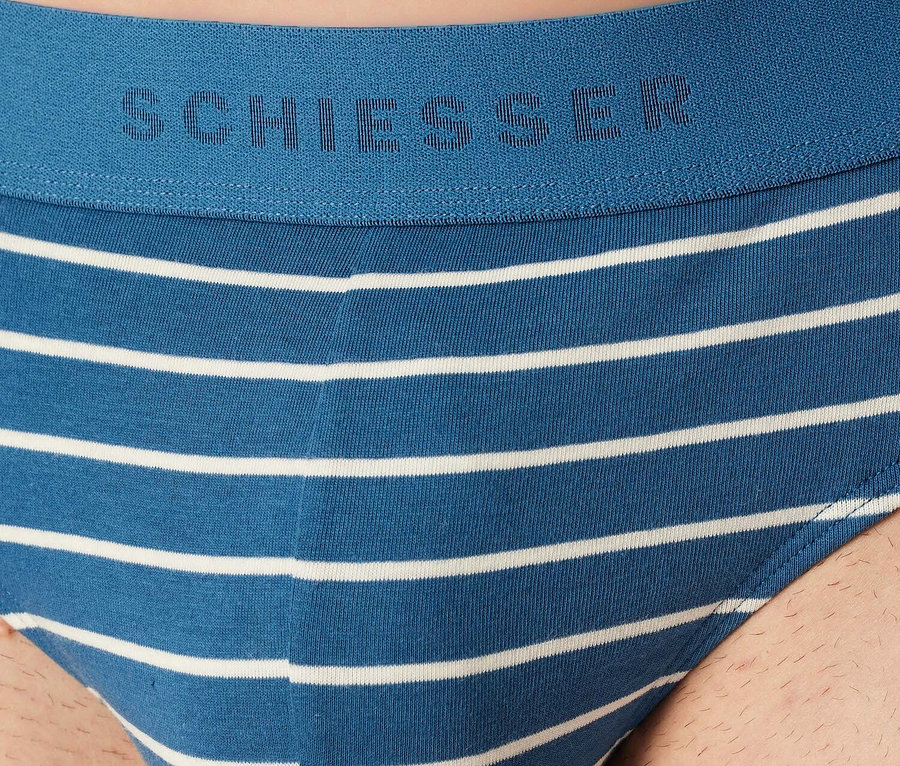 Zbliżenie na niebieskie slipy męskie Schiesser w białe poziome paski.
