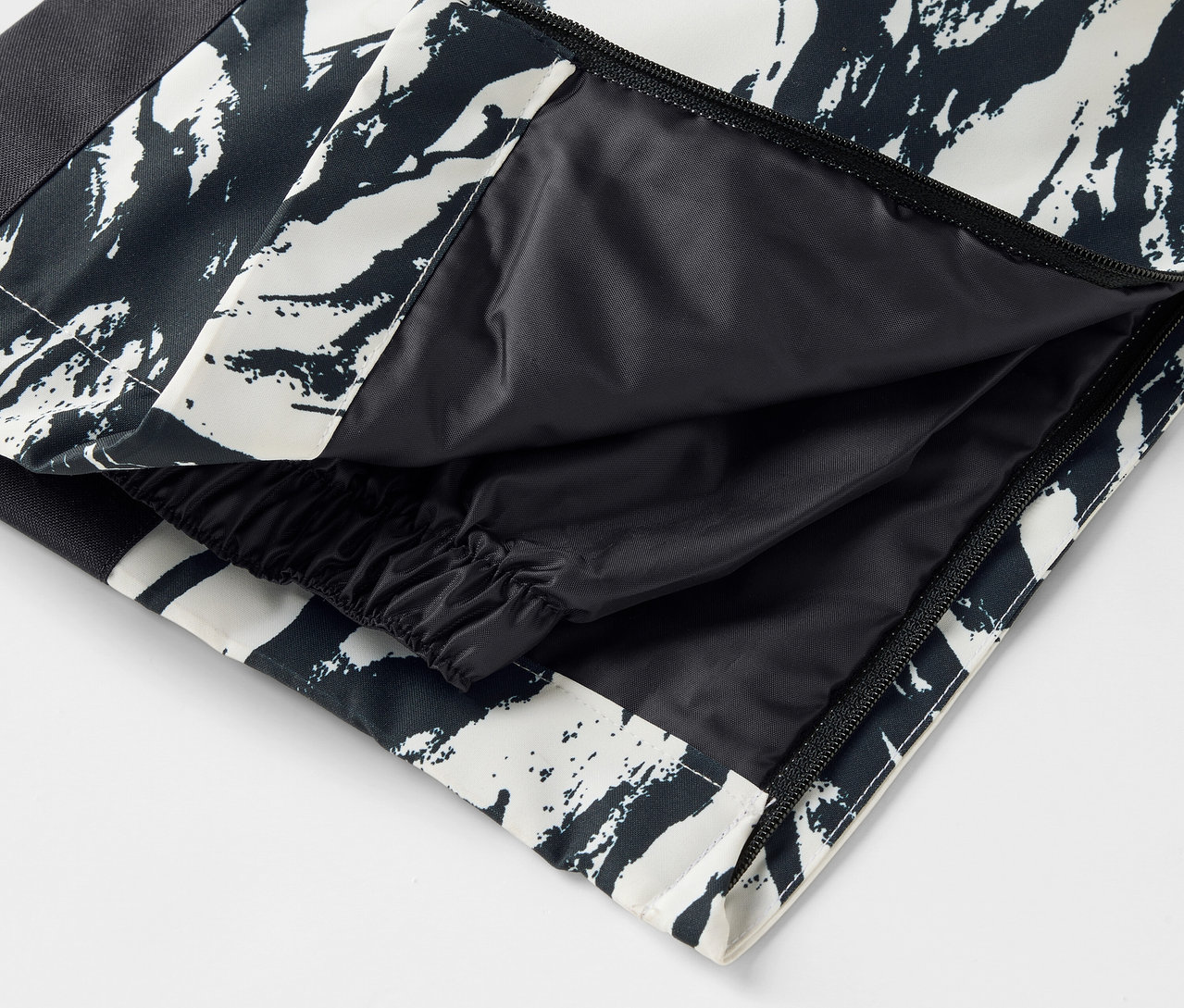 Szczegół czarno-białych spodni we wzory z otwartą kieszenią.