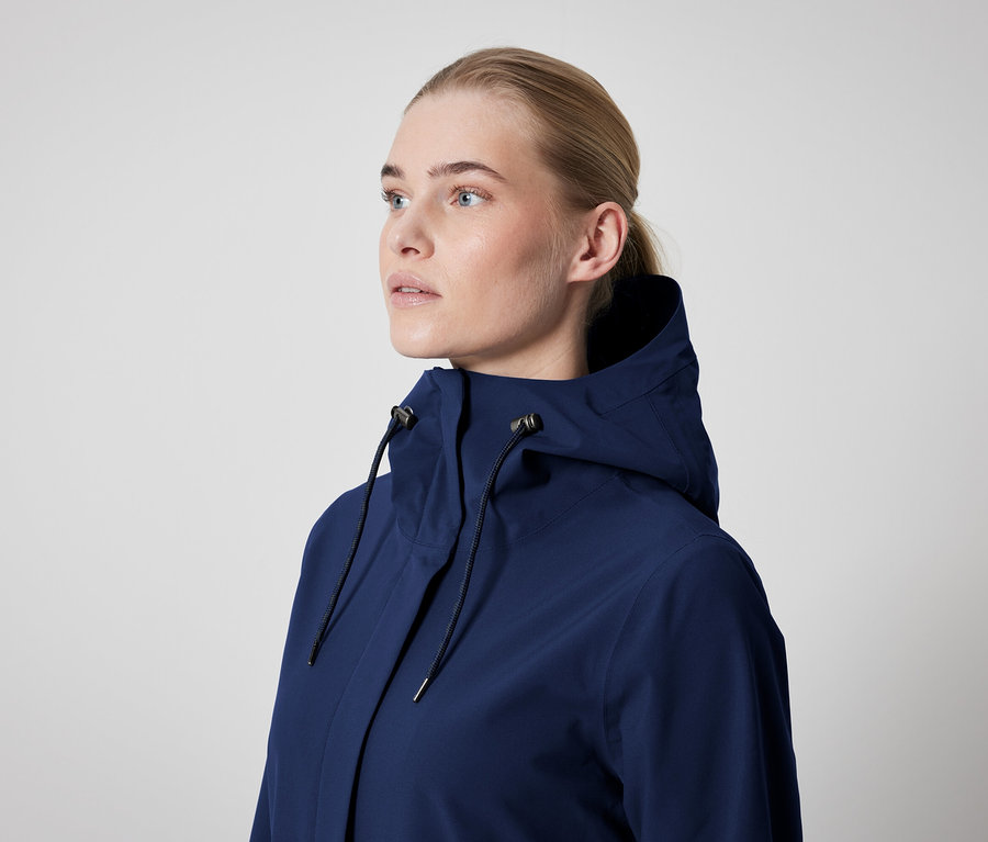 Kobieta ma na sobie granatową kurtkę z kapturem.
