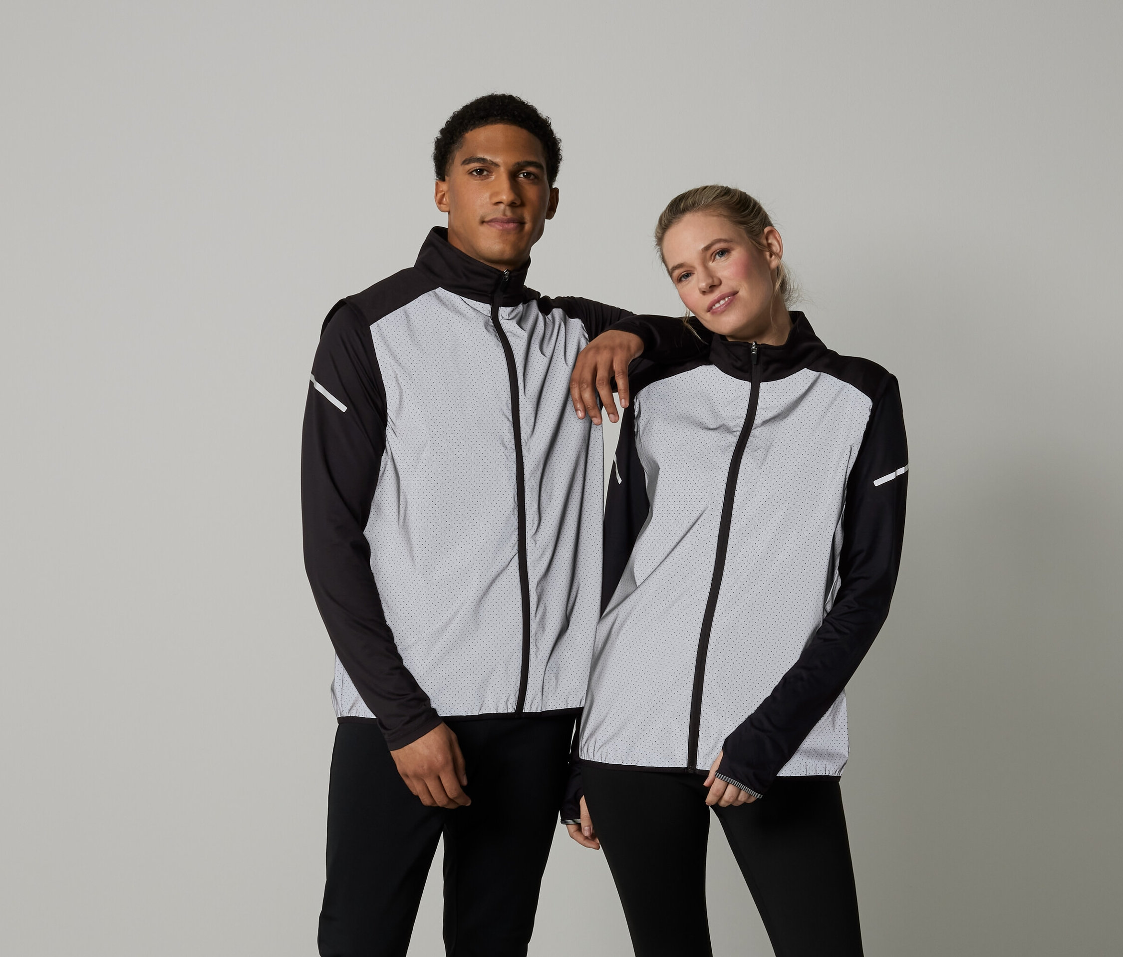 Mężczyzna i kobieta pozują w kurtkach z długim rękawem zapinanych na zamek.