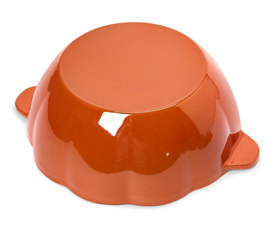 Brązowa miska w kształcie dyni leży dnem do góry na białym tle.