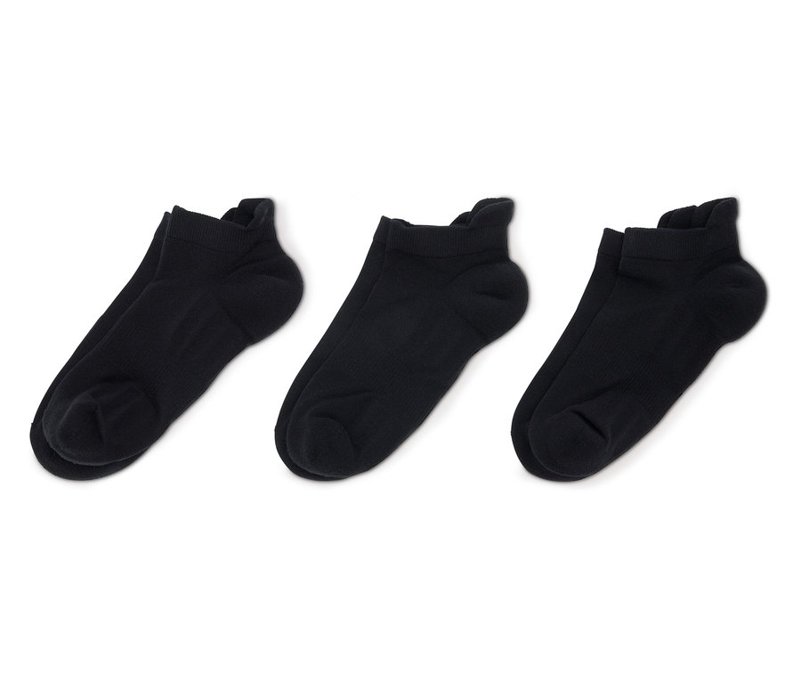 Trzy pary czarnych, krótkich skarpet na białym tle.