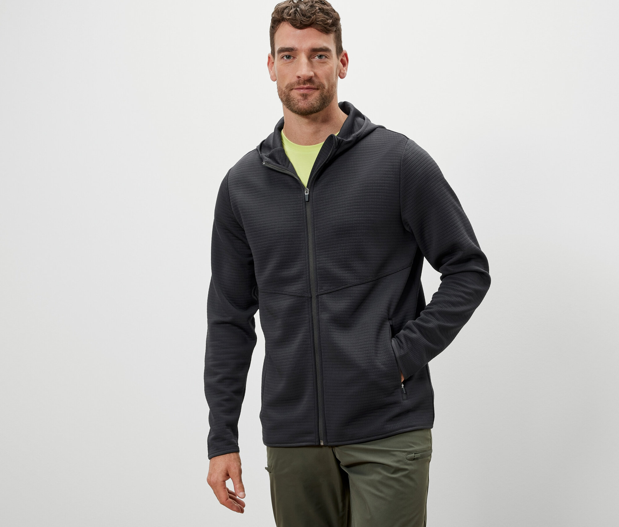Mężczyzna ma na sobie antracytową bluzę funkcyjną.