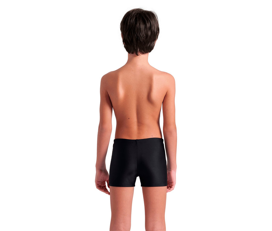 Widok z tyłu dziecka z krótkimi brązowymi włosami ubranego w czarne kąpielówki.