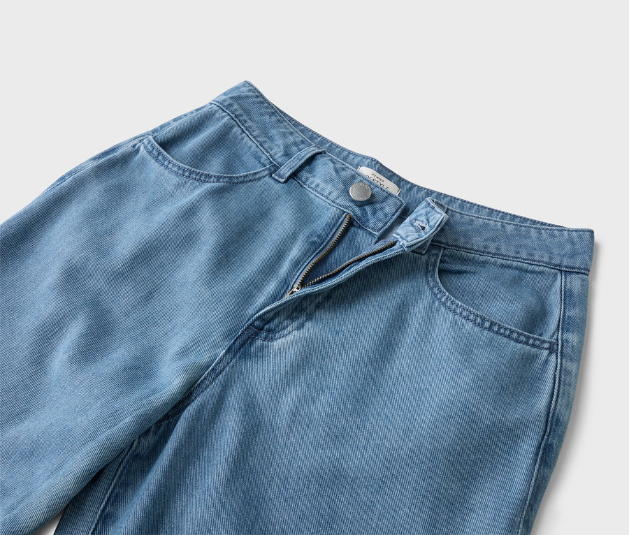 Zbliżenie jasnoniebieskich dżinsów z otwartym zamkiem błyskawicznym.