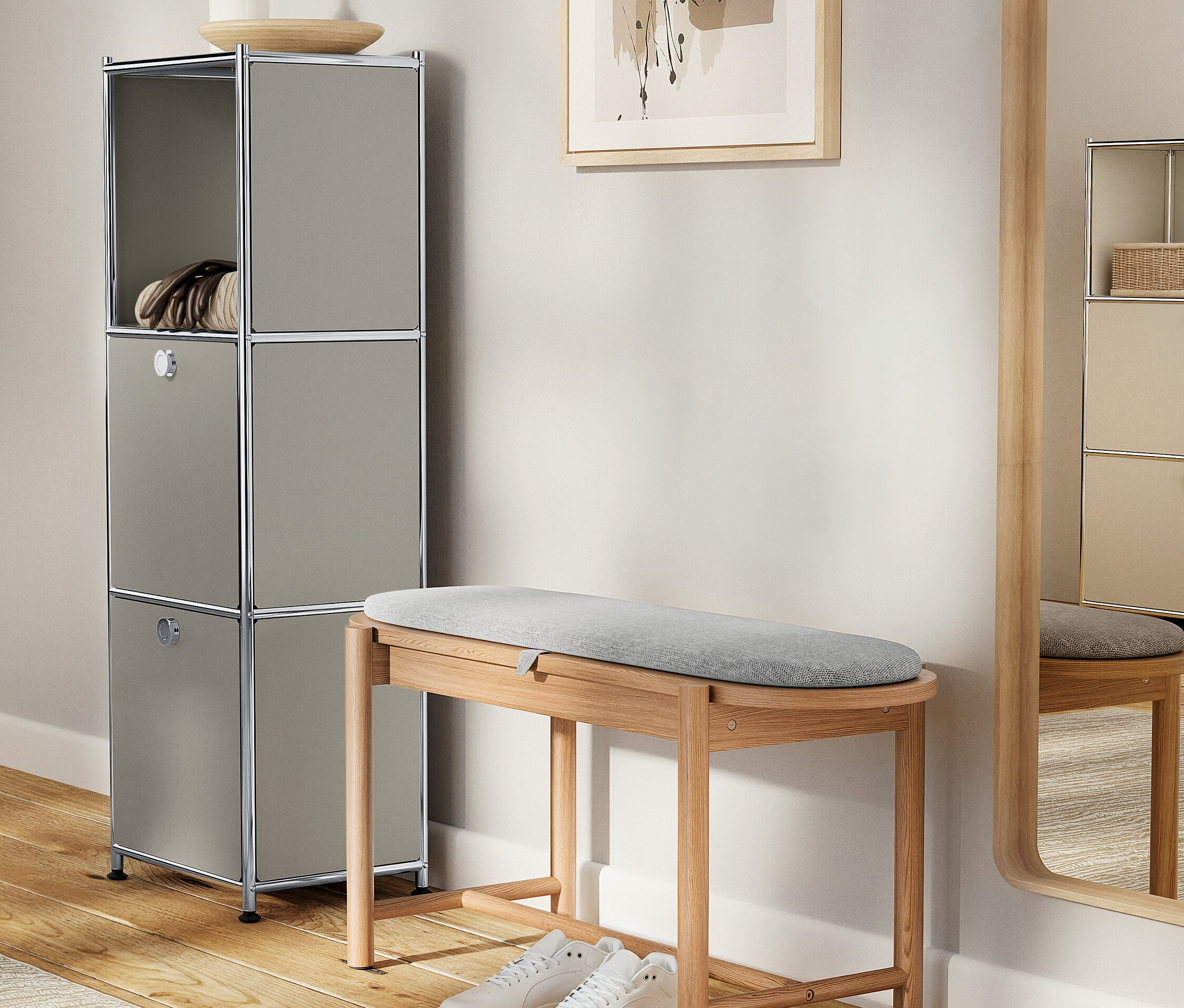 Szara szafka z dekoracjami stoi obok drewnianej ławki z szarą tapicerką i białymi butami.