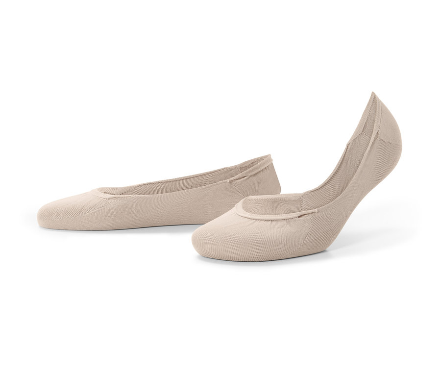 Dwie pary cielistych stopek leżą na podłożu.