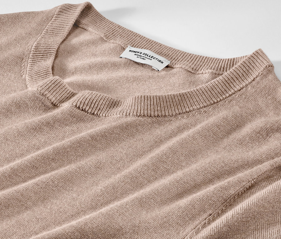 Zbliżenie na jasno-brązową sukienkę z cienkiej dzianiny.