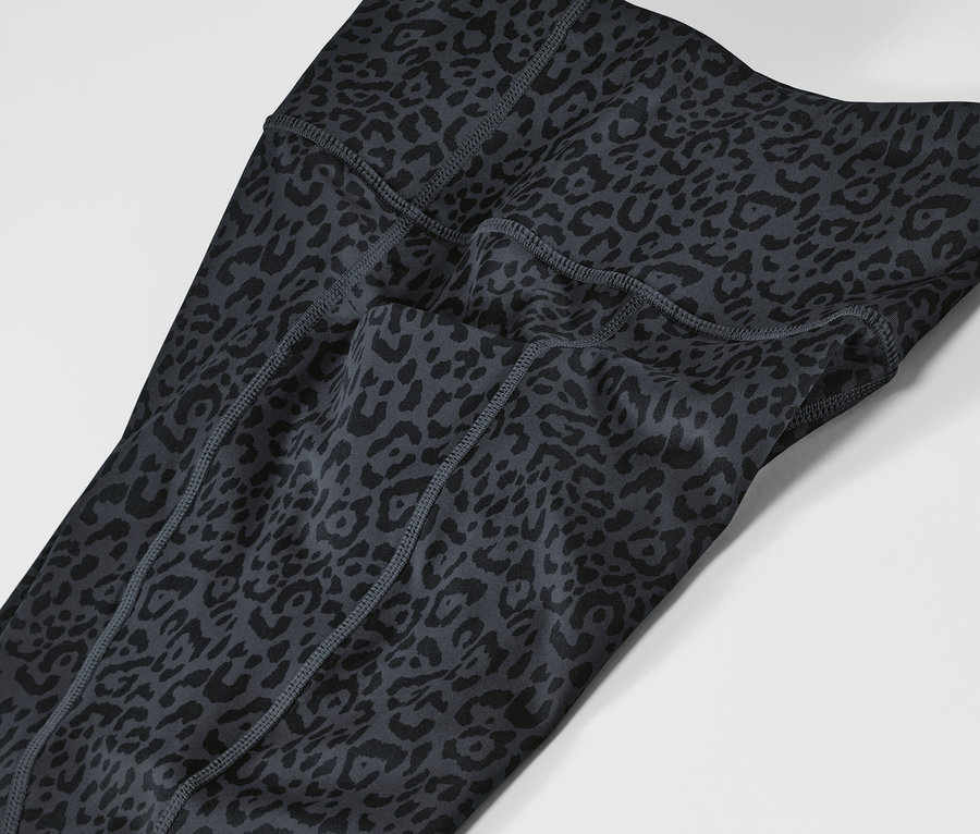 Zbliżenie na szaro-czarne legginsy sportowe we wzór zwierzęcy.