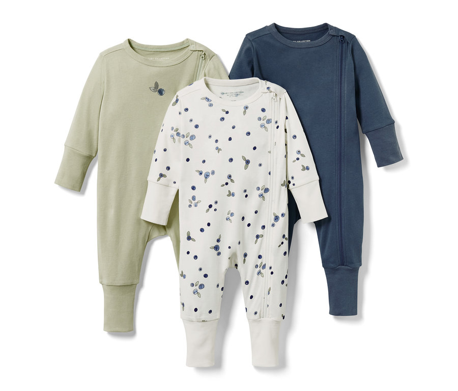 Trzy piżamy dziecięce: jasnozielona, biała w jagody i granatowa.