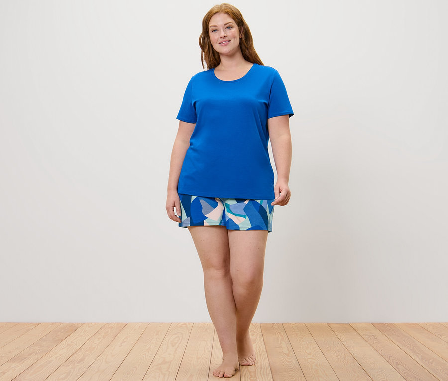 Kobieta ma na sobie piżamę z krótkimi spodenkami.