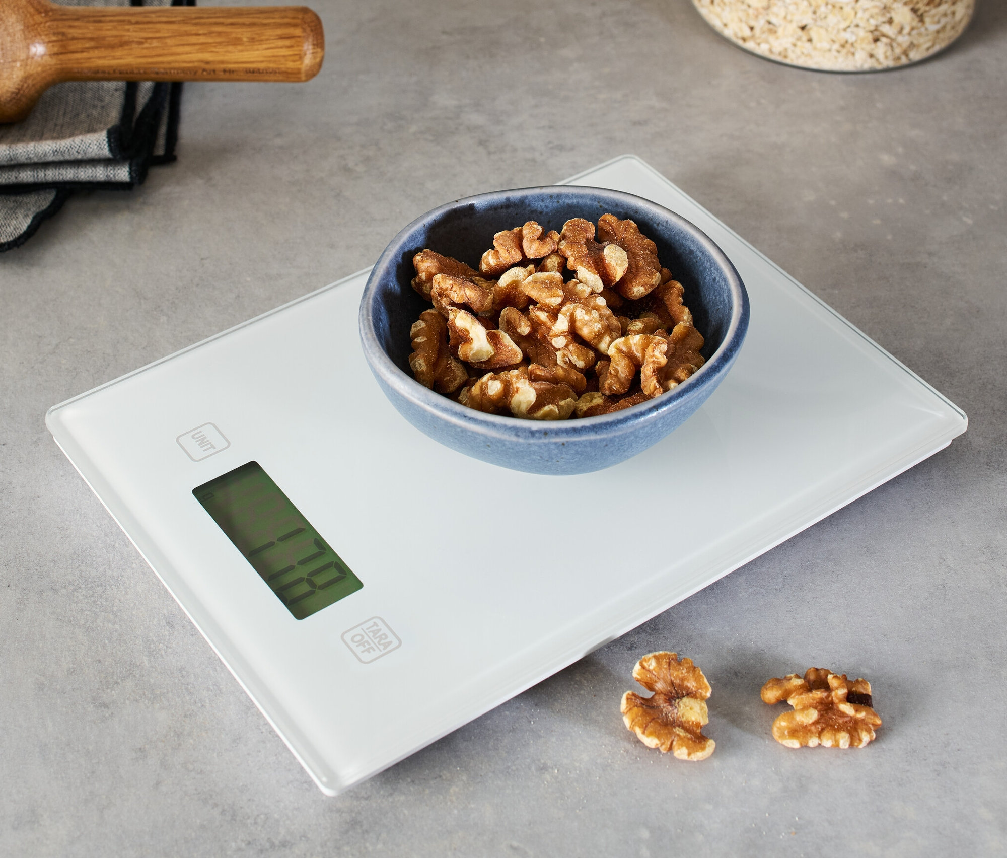 Miska orzechów włoskich na cyfrowej wadze kuchennej.